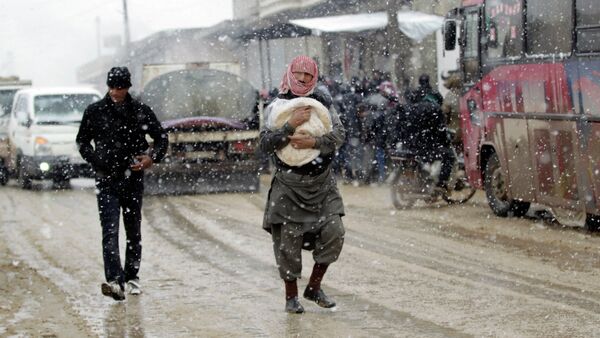 A man carries a bag of bread during a snow storm in Kafranbel town in the Idlib governorate January 15, 2015 - Sputnik International