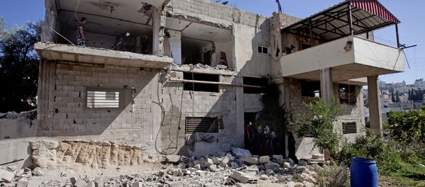 Palestinian inspect the home of Palestinian Ziad Awad in the town of Idna,13 kilometers (8 miles) west of the West Bank city of Hebron, Wednesday, July 2, 2014 Palestinian inspect the home of Palestinian Ziad Awad in the town of Idna,13 kilometers (8 miles) west of the West Bank city of Hebron, Wednesday, July 2, 2014 - Sputnik International