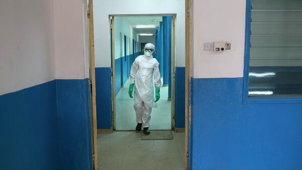 A health worker in protective gear walks inside a Red Cross facility in the town of Koidu, Kono district in Eastern Sierra Leone December 19, 2014 - Sputnik International