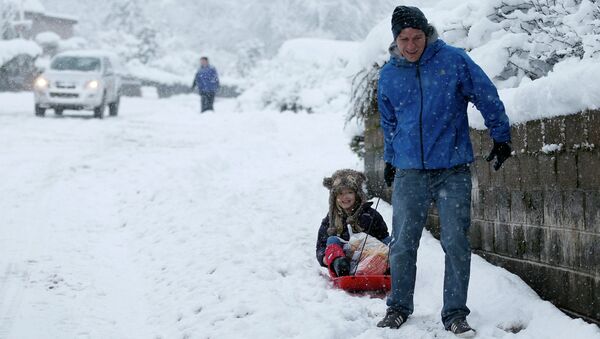 A man pulls a child on a sledge as they return from shopping in Pitlochry, central Scotland January 14, 2015 - Sputnik International