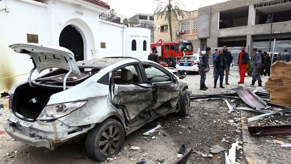 Libyan policemen stand next to a burnt car - Sputnik International