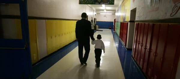 Principal Milton Andrew walks with a kindergarten student to comfort the child during the first day of class at Wilkins Elementary School in Detroit, Thursday, Sept. 14, 2006 - Sputnik International
