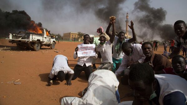 A man (2nd L) holds a sign reading Charlie and his allies are damned during a protest in Niamey Niger, January 17, 2015 - Sputnik International