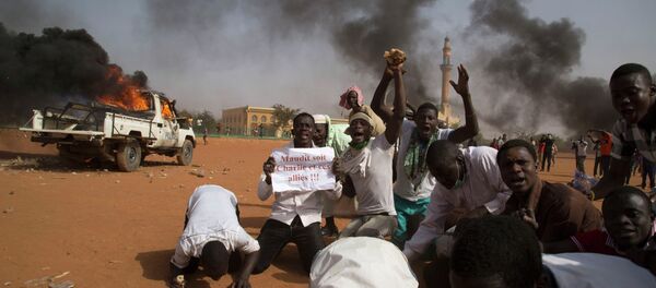 A man (2nd L) holds a sign reading Charlie and his allies are damned during a protest in Niamey Niger, January 17, 2015 A man (2nd L) holds a sign reading Charlie and his allies are damned during a protest in Niamey Niger, January 17, 2015 - Sputnik International