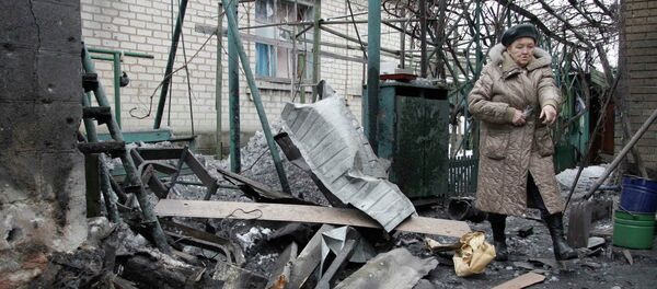 A woman looks at debris in front of a house, which according to locals, was recently damaged by shelling, in Donetsk, eastern Ukraine, January 17, 2015 - Sputnik International