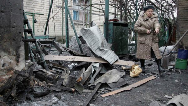 A woman looks at debris in front of a house, which according to locals, was recently damaged by shelling, in Donetsk, eastern Ukraine, January 17, 2015 - Sputnik International