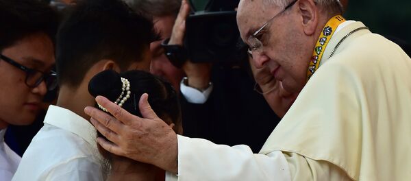Pope Francis (R) reaches out to a child during his visit to the University of Santo Tomas in Manila Pope Francis (R) reaches out to a child during his visit to the University of Santo Tomas in Manila - Sputnik International