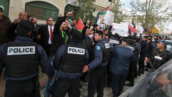 Palestinian policemen hold back demonstrators protesting against Canadian Foreign Minister John Baird, as Baird meets with his Palestinian counterpart in the West Bank city of Ramallah, January 18, 2015. - Sputnik International