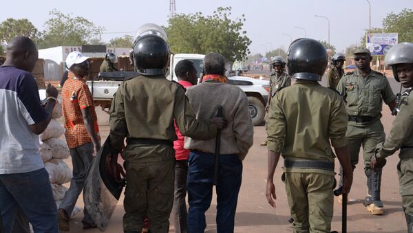 Police officers walk next to protesters as they disperse a banned opposition demonstration in the capital Niamey on January 18, 2015 - Sputnik International