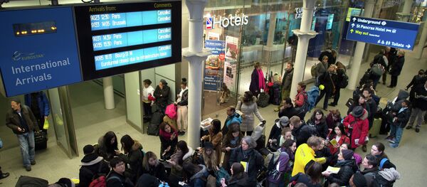 Passengers wait in the long queues at Saint Pancras International station in London - Sputnik International