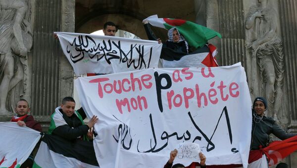 French Muslim youths hold a Islamic flag (top) and a banner reading Do not touch my prophet, anything but the Messenger of Allah as they gather in central Paris January 18, 2015 - Sputnik International