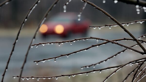 A car drives slowly in the rain on an icy rural road Sunday, Jan. 18, 2015, near Newtown, Pa. - Sputnik International