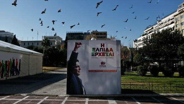 A flock of pigeons flies over a banner with an image of opposition leader and head of radical leftist Syriza party Alexis Tsipras at the party's pre-election kiosk in Athens January 15, 2015. - Sputnik International