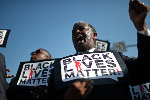 Men holding signs reading Black Lives Matter march in the 30th annual Kingdom Day Parade in honor of Dr. Martin Luther King Jr. Men holding signs reading Black Lives Matter march in the 30th annual Kingdom Day Parade in honor of Dr. Martin Luther King Jr. - Sputnik International