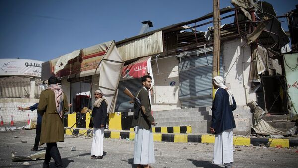 Houthi Shiite Yemeni stand guard in front of a building damaged during recent clashes near the presidential palace in Sanaa, Yemen, Tuesday, Jan. 20, 2015. - Sputnik International