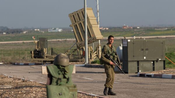An Israeli soldier guards an Iron Dome air defense system deployed in the Israeli controlled Golan Heights near the border with Syria, Tuesday, Jan. 20, 2015. - Sputnik International
