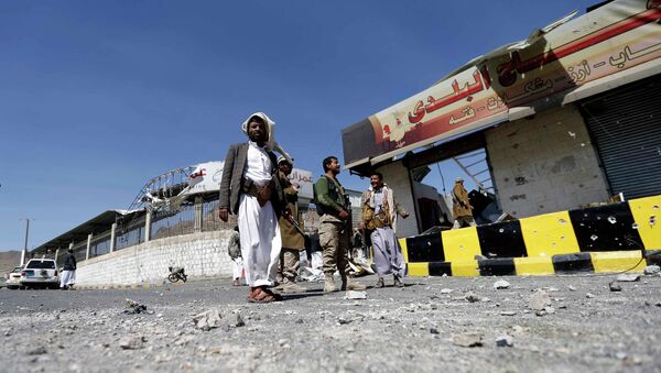 Houthi fighters stand next to damaged shops outside a Presidential Guards barracks on a mountain overlooking Presidential Palace in Sanaa - Sputnik International