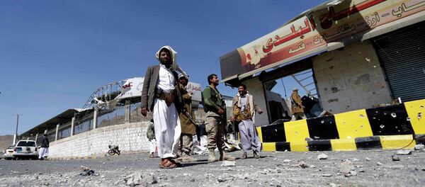 Houthi fighters stand next to damaged shops outside a Presidential Guards barracks on a mountain overlooking Presidential Palace in Sanaa - Sputnik International