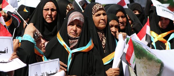 Iraqi women hold placards reading in Arabic: Help women who are abused by DAESH (Islamic State ) during a demonstration to denounce abuse against women by jihadists from the Islamic State Iraqi women hold placards reading in Arabic: Help women who are abused by DAESH (Islamic State ) during a demonstration to denounce abuse against women by jihadists from the Islamic State - Sputnik International