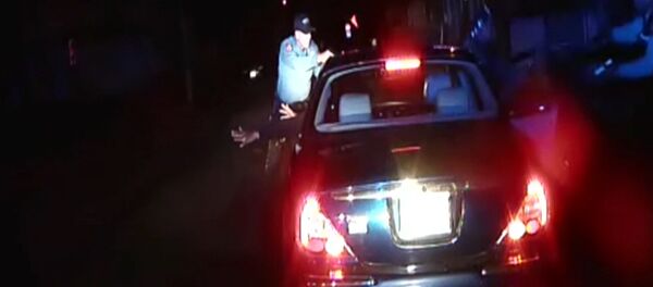 In this frame grab from an officer's dashboard camera taken Dec. 30, 2014, and provided by the Bridgeton, N..J. Police Department, police officers Braheme Days and Roger Worley stand near a car they pulled over for running a stop sign in Bridgeton In this frame grab from an officer's dashboard camera taken Dec. 30, 2014, and provided by the Bridgeton, N..J. Police Department, police officers Braheme Days and Roger Worley stand near a car they pulled over for running a stop sign in Bridgeton - Sputnik International