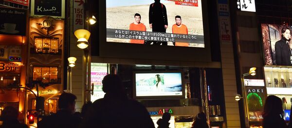 People look at a large TV screen in Tokyo on January 20, 2015 showing news reports about two Japanese men (in orange) who have been kidnapped by the Islamic State group People look at a large TV screen in Tokyo on January 20, 2015 showing news reports about two Japanese men (in orange) who have been kidnapped by the Islamic State group - Sputnik International