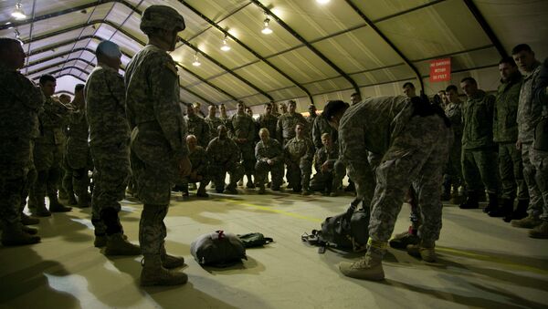 US Army soldiers of the 4th Infantry Brigade, Combat team (Airborne) 25th Infantry Division, part of the NATO-led peacekeeping mission in Kosovo listen to jump master how to prepare their gear for a parachute training exercise in US military base Camp Bondsteel, near the village of Sojeve in Kosovo on Sunday, Dec. 21, 2014 - Sputnik International