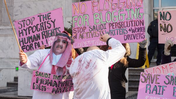 Protesters simulate a flogging in front of the Saudi embassy in Washington,DC on January 15, 2015 during a demonstration against the 10-year prison sentence and 1,000 lashes of Saudi activist Raef Badawi for insulting Islam in a blogpost - Sputnik International