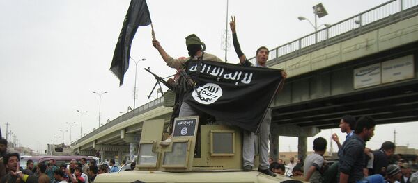 In this file photo, Islamic State group militants hold up their flag as they patrol in a commandeered Iraqi military vehicle in Fallujah, 40 miles (65 kilometers) west of Baghdad, Iraq - Sputnik International