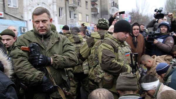 Leader of the self-declared Donetsk People's Republic Alexander Zakharchenko (L) stands next to kneeling captive Ukrainian soldiers at a bus stop where 13 people were killed in a trolleybus shelling in Donetsk, eastern Ukraine, on January 22, 2015 - Sputnik International