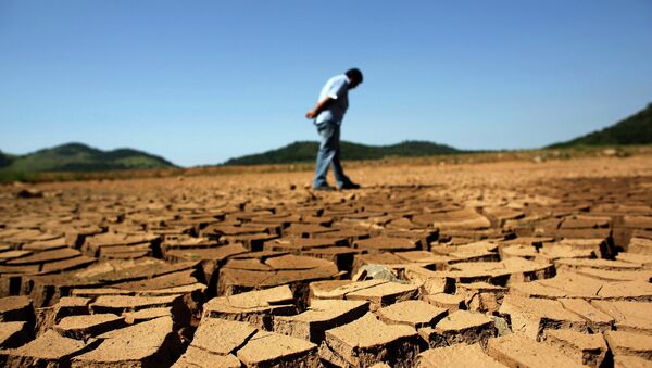 A worker from the Sao Paulo state company that provides water and sewage services to residential, commercial and industrial areas looks at the cracked ground of near Jaguary dam in Braganca Paulista, 100 km from Sao Paulo, in this file photo taken January 31, 2014 - Sputnik International