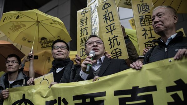 Leading pro-democracy activists, Chan Kin-man (2nd L), Benny Tai Yiu-ting (2nd R) and Chu Yiu-ming (R) hold a banner in front of the Wanchai police station in Hong Kong on January 24, 2015 - Sputnik International
