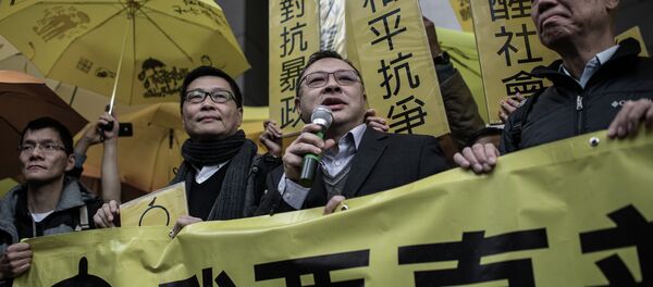 Leading pro-democracy activists, Chan Kin-man (2nd L), Benny Tai Yiu-ting (2nd R) and Chu Yiu-ming (R) hold a banner in front of the Wanchai police station in Hong Kong on January 24, 2015 Leading pro-democracy activists, Chan Kin-man (2nd L), Benny Tai Yiu-ting (2nd R) and Chu Yiu-ming (R) hold a banner in front of the Wanchai police station in Hong Kong on January 24, 2015 - Sputnik International