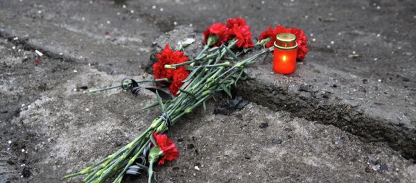 A candle and flowers are layed at a bus stop where 13 people were killed in a trolleybus shelling in Donetsk, eastern Ukraine, on January 22, 2015 A candle and flowers are layed at a bus stop where 13 people were killed in a trolleybus shelling in Donetsk, eastern Ukraine, on January 22, 2015 - Sputnik International