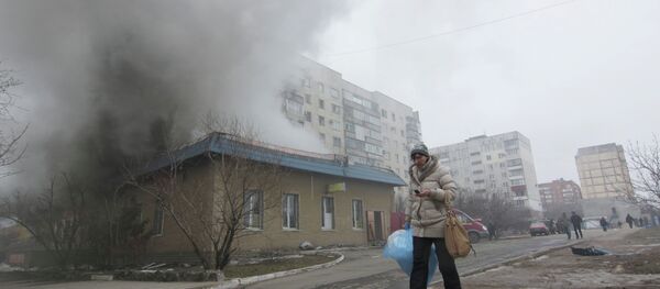 A woman resident passes by a burning house in Mariupol, Ukraine, Saturday, Jan. 24, 2015 A woman resident passes by a burning house in Mariupol, Ukraine, Saturday, Jan. 24, 2015 - Sputnik International