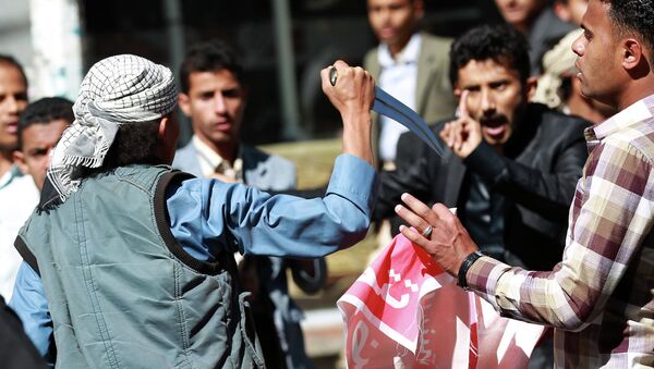 A Shiite Huthi rebel threatens Yemeni protesters during a rally against the control of the capital by Huthi rebels on January 24, 2015 in the capital Sanaa - Sputnik International