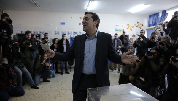 Alexis Tsipras, leader of Greece's Syriza left-wing main opposition party surrounded by photographers reacts as he casts his vote at a polling station in Athens, Sunday, Jan. 25, 2015 - Sputnik International
