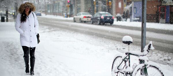 A woman walks past a bicycle covered in snow during a winter snowstorm in Cambridge, Massachusetts January 24, 2015 A woman walks past a bicycle covered in snow during a winter snowstorm in Cambridge, Massachusetts January 24, 2015 - Sputnik International