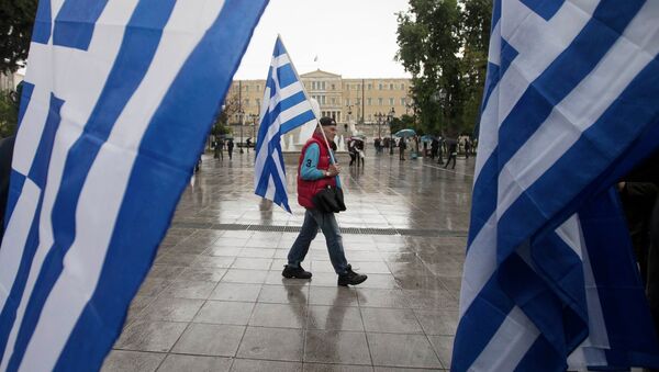 A man holding a Greek flag walks on central Syntagma square as the parliament is seen in the background, in Athens January 24, 2015 - Sputnik International