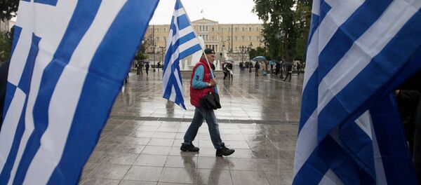 A man holding a Greek flag walks on central Syntagma square as the parliament is seen in the background, in Athens January 24, 2015 A man holding a Greek flag walks on central Syntagma square as the parliament is seen in the background, in Athens January 24, 2015 - Sputnik International