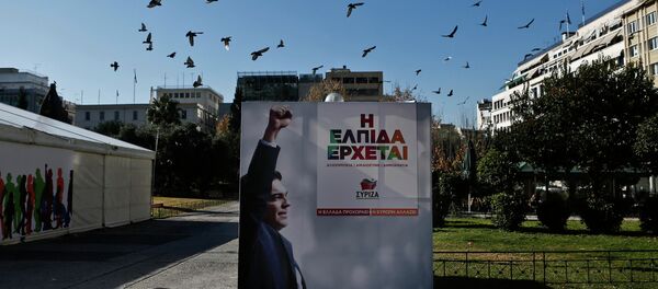 A flock of pigeons flies over a banner with an image of opposition leader and head of radical leftist Syriza party Alexis Tsipras at the party's pre-election kiosk in Athens January 15, 2015. - Sputnik International