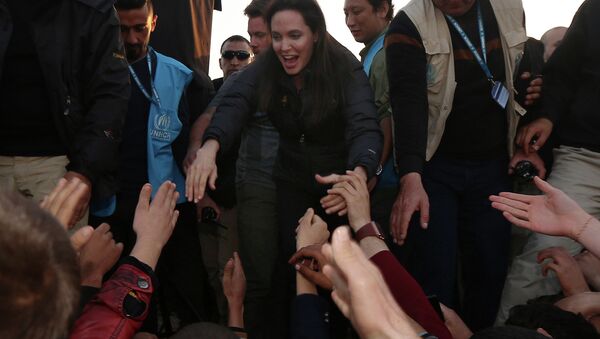 US actress and UNHCR ambassador Angelina Jolie (C) greets displaced Iraqi children during a visit to a camp for displaced people in Khanke, a few kilometres (miles) from the Turkish border in Iraq's Dohuk province - Sputnik International