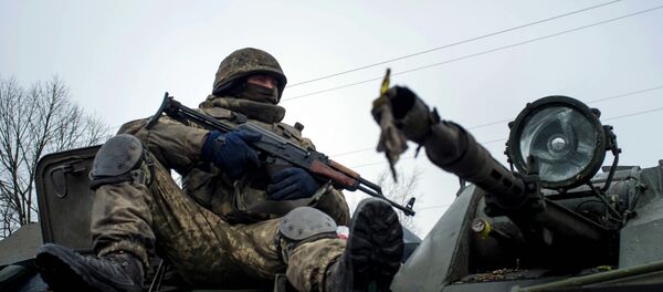 A Ukrainian serviceman rides on APC - Sputnik International