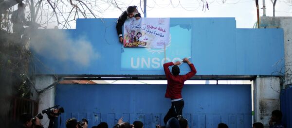 A Palestinian man puts a sign at the gate of the headquarters of the United Nations Special Coordinator A Palestinian man puts a sign at the gate of the headquarters of the United Nations Special Coordinator - Sputnik International