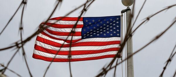 An American Flag is seen through razor wire at Camp VI in Camp Delta where detainees are housed at Naval Station Guantanamo Bay in Cuba - Sputnik International