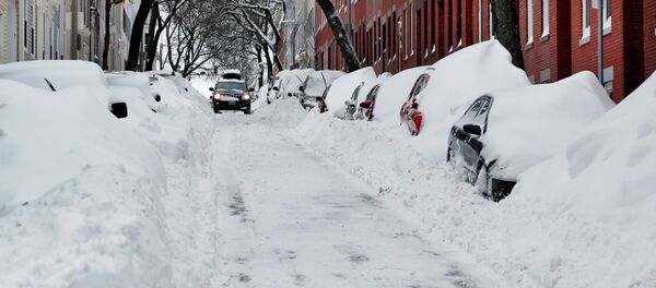 A car makes its way down a street filled with snowed-in vehicles in Boston's Charlestown section, Wednesday, Jan. 28, 2015 one day after a blizzard dumped about two feet of snow in the city A car makes its way down a street filled with snowed-in vehicles in Boston's Charlestown section, Wednesday, Jan. 28, 2015 one day after a blizzard dumped about two feet of snow in the city - Sputnik International