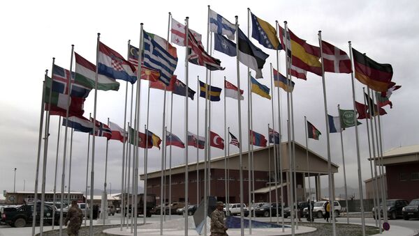 NATO Soldiers walk under country member flags at a NATO base at Kabul International Airport in Kabul, Afghanistan - Sputnik International