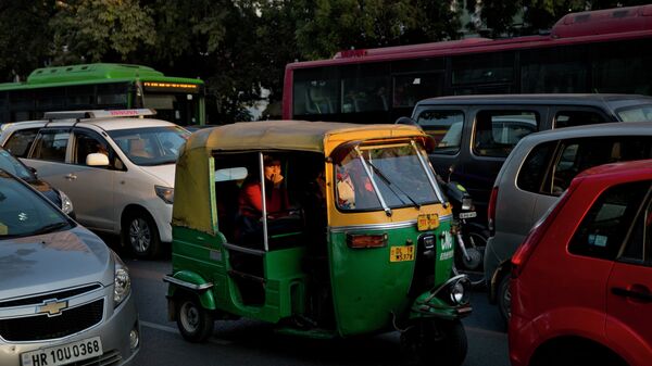 An Indian woman passenger looks at camera as she travels in an auto-rickshaw, a cheaper mode of three wheeler taxi service in New Delhi, India - Sputnik International