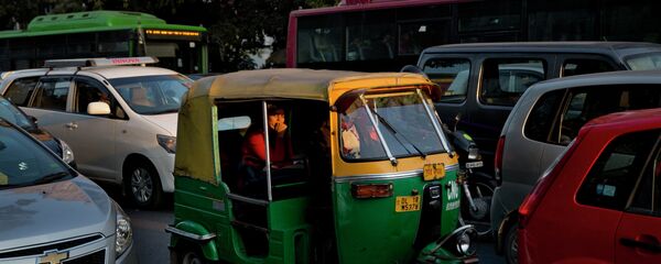 An Indian woman passenger looks at camera as she travels in an auto-rickshaw, a cheaper mode of three wheeler taxi service in New Delhi, India - Sputnik International