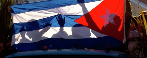 Children's shadows are cast on a Cuban national flag as they take part in a caravan tribute marking the 56th anniversary of the original street party that greeted a triumphant Castro and his rebel army, in Regla, Cuba, Thursday, Jan. 8, 2015 Children's shadows are cast on a Cuban national flag as they take part in a caravan tribute marking the 56th anniversary of the original street party that greeted a triumphant Castro and his rebel army, in Regla, Cuba, Thursday, Jan. 8, 2015 - Sputnik International