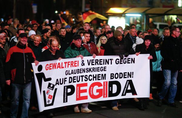 Participants hold a banner during a demonstration called by anti-immigration group PEGIDA, a German abbreviation for Patriotic Europeans against the Islamization of the West, in Dresden December 15, 2014 Participants hold a banner during a demonstration called by anti-immigration group PEGIDA, a German abbreviation for Patriotic Europeans against the Islamization of the West, in Dresden December 15, 2014 - Sputnik International